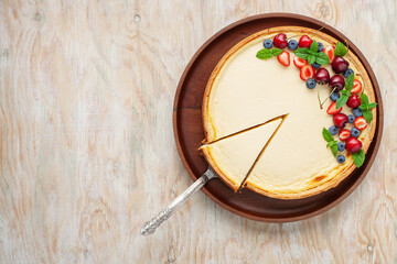 Cheesecake New York with berries on a plate on a bright background. Top view