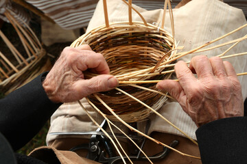 elderly craftsman while weaving a wicker basket