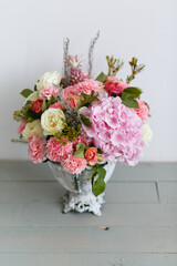 Vase with beautiful bouquet on background of white wall. Pink flowers in a vase. Floristic composition. Mock up