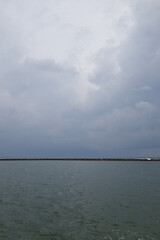  Maldivian island on the horizont seen wrom the green greish ocean water