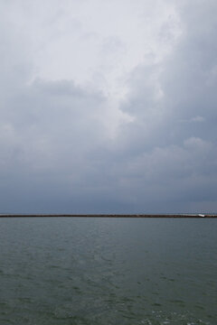  Maldivian island on the horizont seen wrom the green greish ocean water