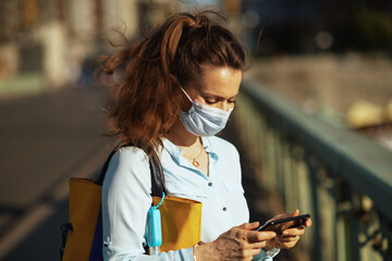 woman sending text message using smartphone outdoors in city