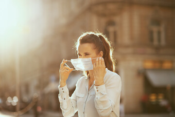 modern woman outdoors in city wearing medical mask