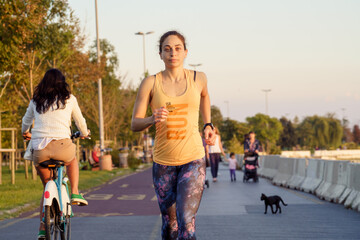  Fit woman running alone on the beach at sunset. She is exercising for a healthy life.