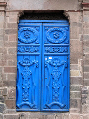 A blue wooden door with floral ornaments in Cuzco old town, Peru. 