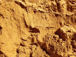Yellow crumbly sand. Dry soil texture and background. The background of the red soil. Abstract land. Natural abstraction. Clay. Red sand. Texture. Background. Construction. Copy space for text