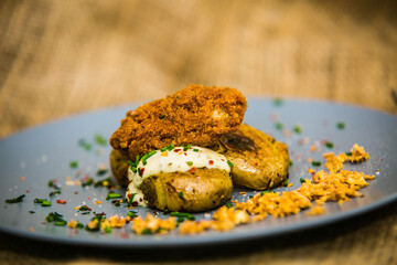 Fried meatball with herb sauce and potato on plate. The food in the restaurant. Food styling and restaurant meal serving. 