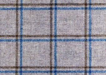 Fototapeta na wymiar Blue and brown color over check on grey woolen fabric. Pastel tones. Country windowpane tweed riding jacket. Shetland wool. High resolution