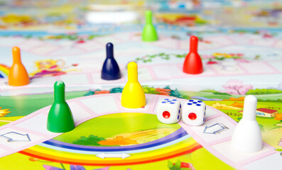 Board games for the home. Yellow, green, blue, red plastic chips and dice on Board games for children . Selective focus
