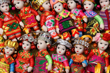 Colorful little dolls in ethnic dress for sale as keychain fobs in market, Dali, Yunnan Province, China