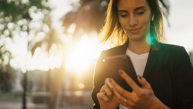 Successful Business Woman Texting On Smartphone Working In Park Barcelona Sun Day, Young Professional Finance Girl Using Mobile Device On Background Sun Flare Outdoors