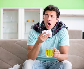 Young handsome man suffering from illness at home