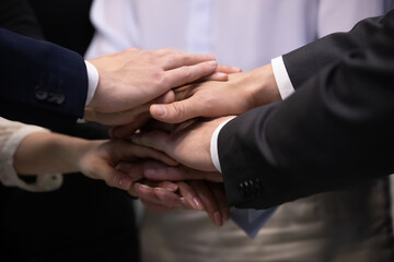 Teamwork concept, close up with joined hands of business people team. Group of diverse businesspeople coworkers stacking hands together as symbol of partnership, collaboration, trust and unity