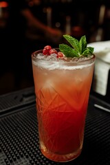 Cranberry summer lemonade decorated with mint on a bar counter