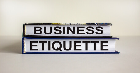Books with text 'business etiquette' on beautiful white table. White background. Business concept. Copy space.
