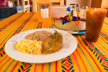 MEXICAN FOOD, CHILLI STUFFED WITH CHEESE WITH RICE AND REFRITED BEANS IN A MEXICAN RESTAURANT