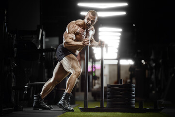 Fototapeta na wymiar bodybuilder fitness man pumping up legs muscles