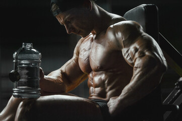 Bodybuilder with protein powder supplements jar