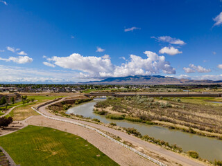 Aerial view of a bike trail along a river with mountains in the distance
