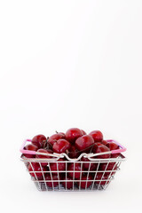 Shopping basket full of ripe sweet berries isolated on white background with copy space. Concept of shopping in supermarket.