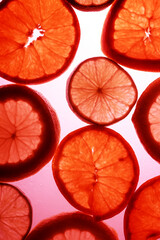  frutas lim&oacute;n, lima y naranja con luz por detr&aacute;s en rojo