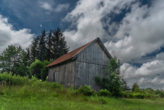 Wooden old barn in cloudy sunny summer hot day in Roprachtice village