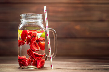 Fruit water with lime, lemon and strawberry n glass bottle. healthy eating, drinks, diet and detox concept.