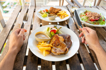 First-person view of a guy eating food in a summer cafe.
