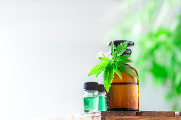 Glass bottles of hemp oil with hemp leaves.