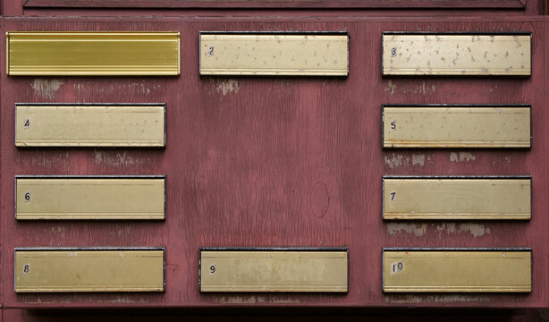 Numbered weathered metal letter boxes on wooden background with copy space