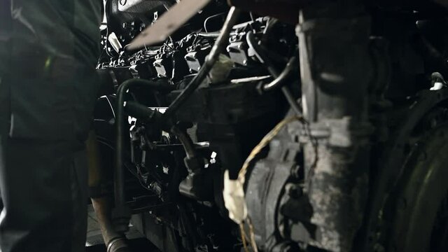 Close View Of Auto Mechanic At Workshop Fixing Components Of Coach Bus Engine. 