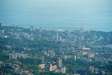Panorama of the center of the coastal city. Lots of buildings and roads. Ships at sea. The seaport is visible. The river flows in the valley. View of the city of Sochi from above.
