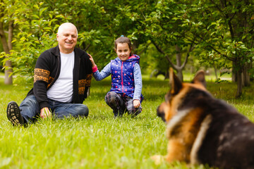 Grandfather and granddaughter relaxing with dog