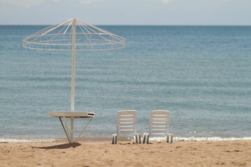 Deck chair in the sand on the shore. Relax, relaxation on the beach. Blue water in the ocean sea.