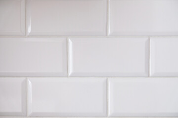 Close up view of white tiled kitchen wall. Typical interior design idea. Clean big rectangular tiles in modern architecture. Geometric pattern suitable for bathroom surface or flooring. Abstract panel