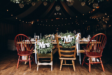 Wooden chairs with letters "Mrs" and "Mr" on wedding