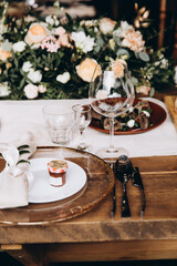 Wedding table decorated with plates, glasses and flowers