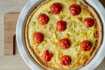 Homemade quiche lorraine with chicken, tomatoes and cheese. French cuisine. Selective focus. Top view. Copy space