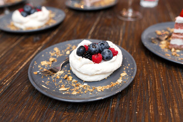 Sweet cakes with summer berries on a wooden table. Party, sweet table. Summer offer desserts in the restaurant.