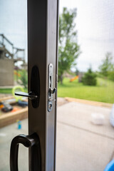 Handle, locking hardware, and jam to a sliding glass and screen door.