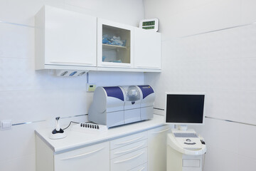 A modern interior of a dental office with a wet milling and grinding machine, an intraoral scanner, a led polymerization light. Dentist’s office. Dental laboratory
