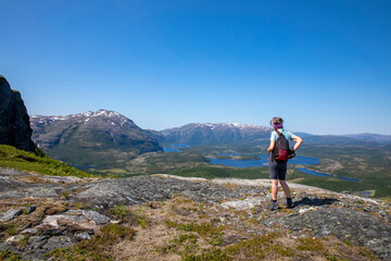 Fototapeta premium Woman on a hike to the mountain Hongfjellet Tosen, Velfjord Northern Norway