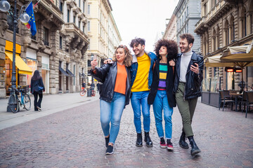 Group of friends walking outdoors having fun -  Friends tourist walking taking selfie - traveller, sociable, togetherness concept