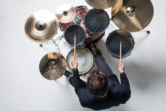 Musician plays musical percussion instrument with drumsticks isolated on white background