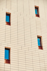 Fototapeta na wymiar The facade of a residential building with narrow windows.