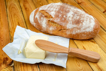 Tasty fresh bread and butter on a wooden table. Bread in the home kitchen.