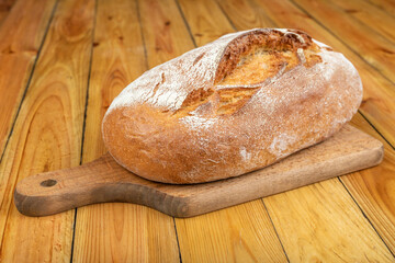 Tasty fresh bread on a wooden table. Bread in the home kitchen.