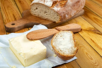 Tasty fresh bread and butter on a wooden table. Bread in the home kitchen.