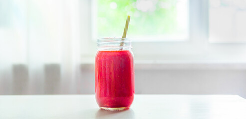 Fresh red smoothie on a white kitchen table. Summer food and drinks. concept banner. Raspberry, strawberry smoothie.
