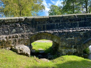 Fototapeta na wymiar Partial view of the bridge over the Linton Beck, with its smaller arch in, Linton, Skipton, UK